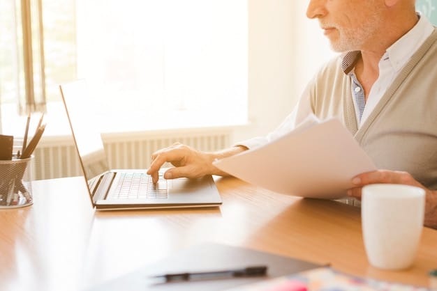 A person working at a desk with a laptop, reviewing Social Security information and retirement planning documents.