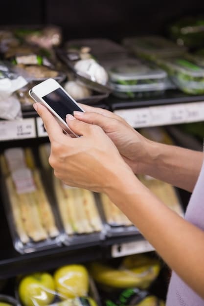 A close-up of a SNAP Electronic Benefit Transfer (EBT) card being used at a grocery store checkout, with fresh produce and other healthy food items visible in the shopping cart.