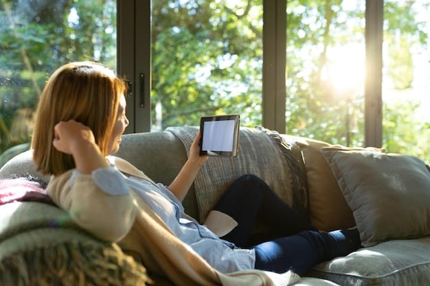 A person relaxing on a sofa, using a tablet to control smart home devices, with a TV showing a nature documentary in the background. Focus on the integration of technology.