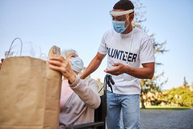 Volunteers distributing aid packages (water, food, blankets) to families at a temporary shelter after a severe weather event, showing diverse individuals.