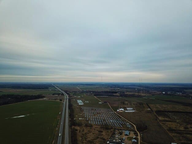 An aerial view of a vast solar panel farm stretching to the horizon, with clear blue skies above, symbolizing large-scale clean energy generation.