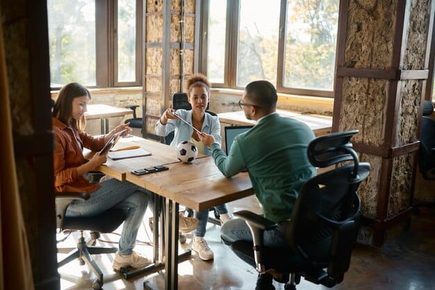 A diverse group of young professionals sitting around a table in a modern co-working space, each focused on their laptops, with glowing digital screens showing LinkedIn job alerts and networking features, symbolizing collaborative career advancement.