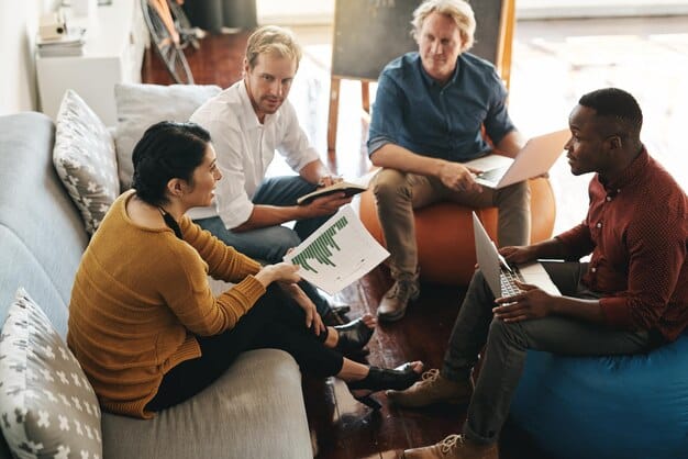 A diverse group of people sitting together in a community center, discussing documents and looking engaged, symbolizing community support and accessing help.