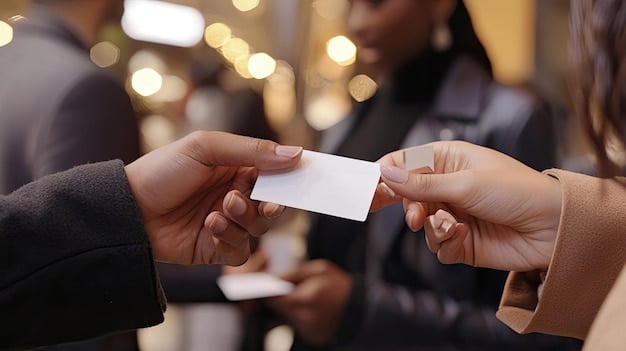 A close-up shot of two people exchanging business cards at a networking event, emphasizing the importance of making personal connections. This visual illustrates a key component of 'The Ultimate Guide to Building a Professional Network That Lands You a Job in 2025', highlighting the value of in-person networking.