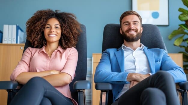 A female professional sitting across from a male executive in a bright office, both smiling and engaged in a mentoring session. The setting showcases The Power of Mentorship as they discuss career strategies and feedback.