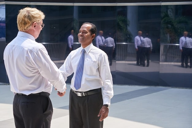 Two people shaking hands firmly at a networking event with name tags visible, representing connecting with potential mentors and building relationships to unlock The Power of Mentorship.