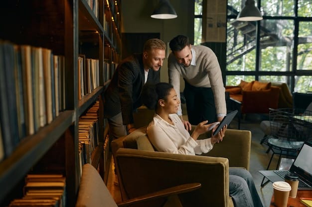 A professional reading a book in a brightly lit office, surrounded by colleagues collaborating. The image showcases the blend of independent learning and collaborative engagement, underscoring The Importance of Continuous Learning: Staying Relevant in a Rapidly Changing Job Market.