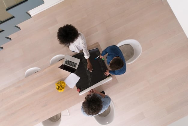 An aerial view of three diverse professionals sitting around a table in a modern office, reviewing documents and discussing solutions, embodying collaborative problem-solving. Natural light streams in from a nearby window, enhancing the positive and cooperative atmosphere. The scene subtly hints at Conflict Resolution in the Workplace: Strategies for Handling Difficult Situations.
