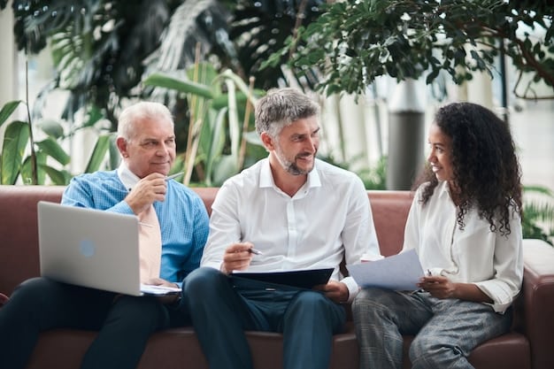 A financial advisor is sitting across from a young couple in their late 30s, explaining the benefits of Long-Term Care Insurance. The advisor is using a tablet to show them a graph illustrating the potential costs of long-term care versus the cost of insurance premiums. The scene portrays proactive financial planning.