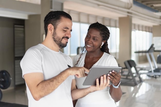 An employee happily participating in a corporate wellness program, using a fitness tracker and consulting with a health coach about 'Understanding Your Employee Health Benefits: A Comprehensive Guide for 2025'. The setting is a modern office gym.